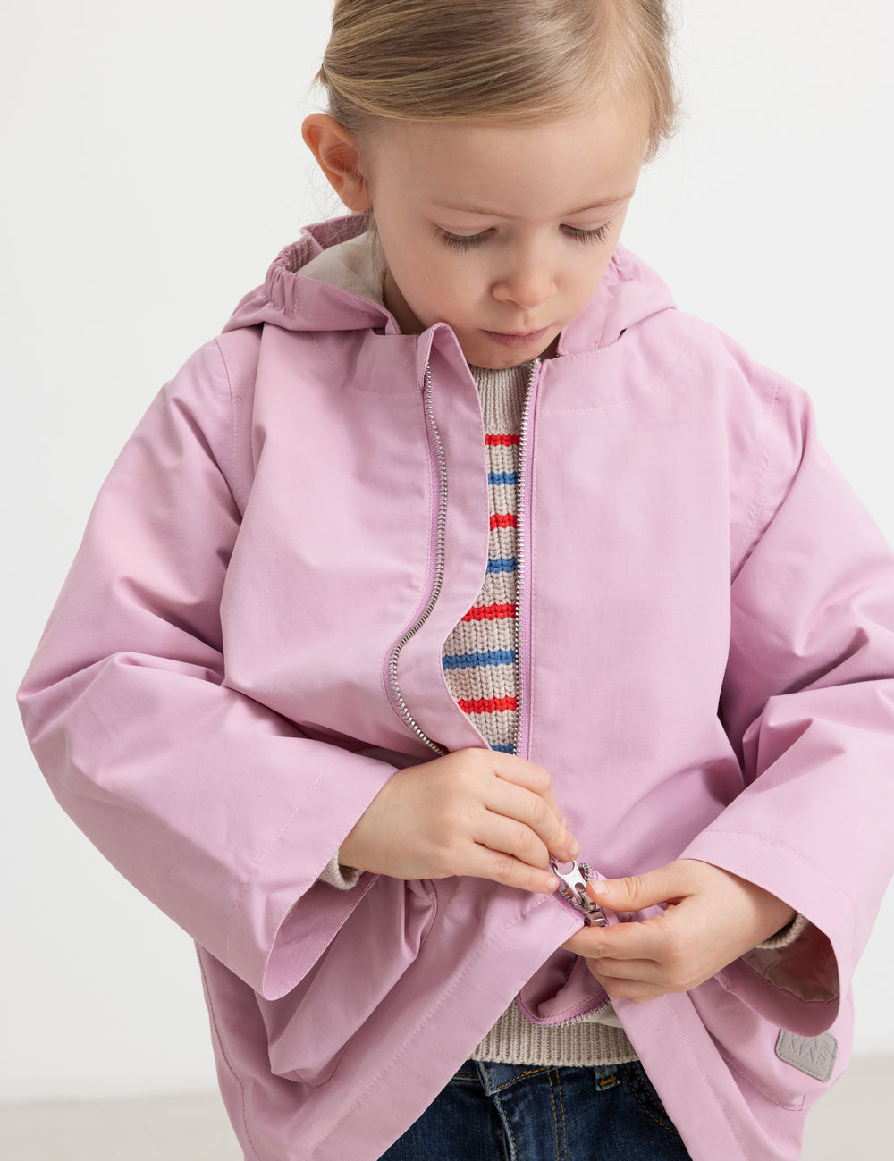 Barn iført stribet striktrøje sammen med lyserød jakke