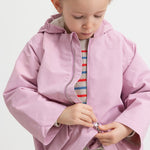 Barn iført stribet striktrøje sammen med lyserød jakke