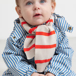 Baby iført blå stribet regndragt og stribet halstørklæde