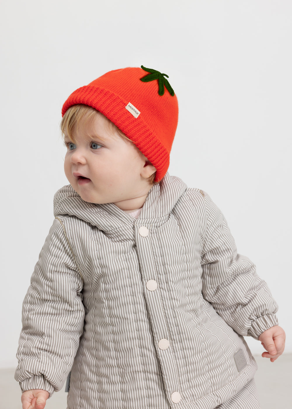 Rød strikhue båret af baby