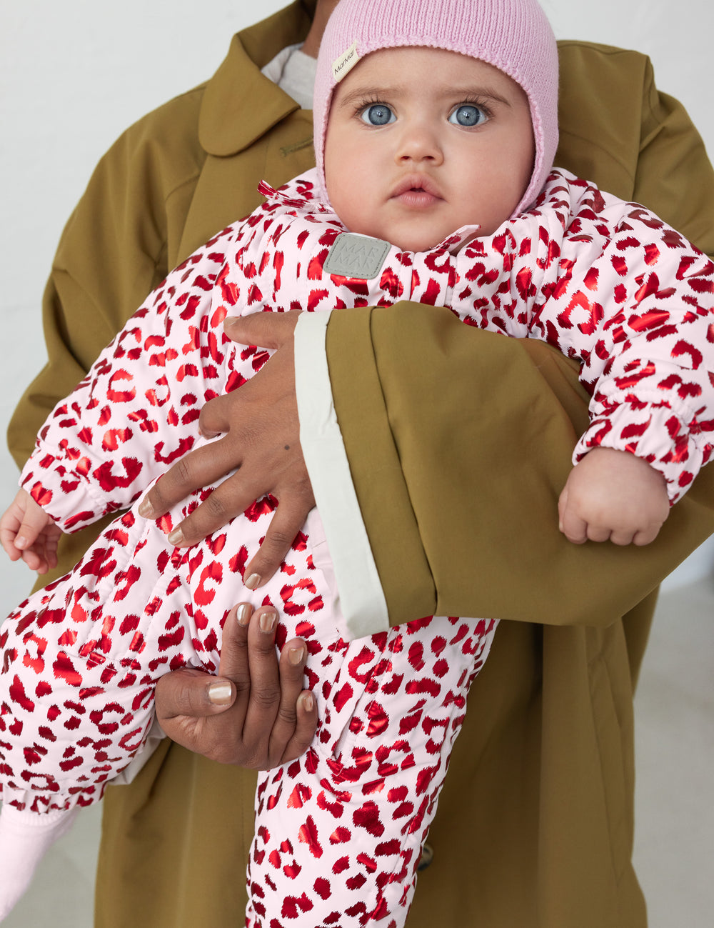 Baby iført lyserød termodragt med leopardprint og rosa hue