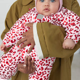 Baby iført lyserød termodragt med leopardprint og rosa hue