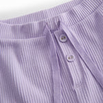 Lilla baby bloomers med stolpe knaplukning og et pyntebånd i livet