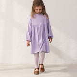 Pige iført lilla kjole og leopard leggings