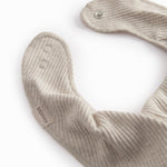 Beige baby salvesmæk som lukkes med trykknap