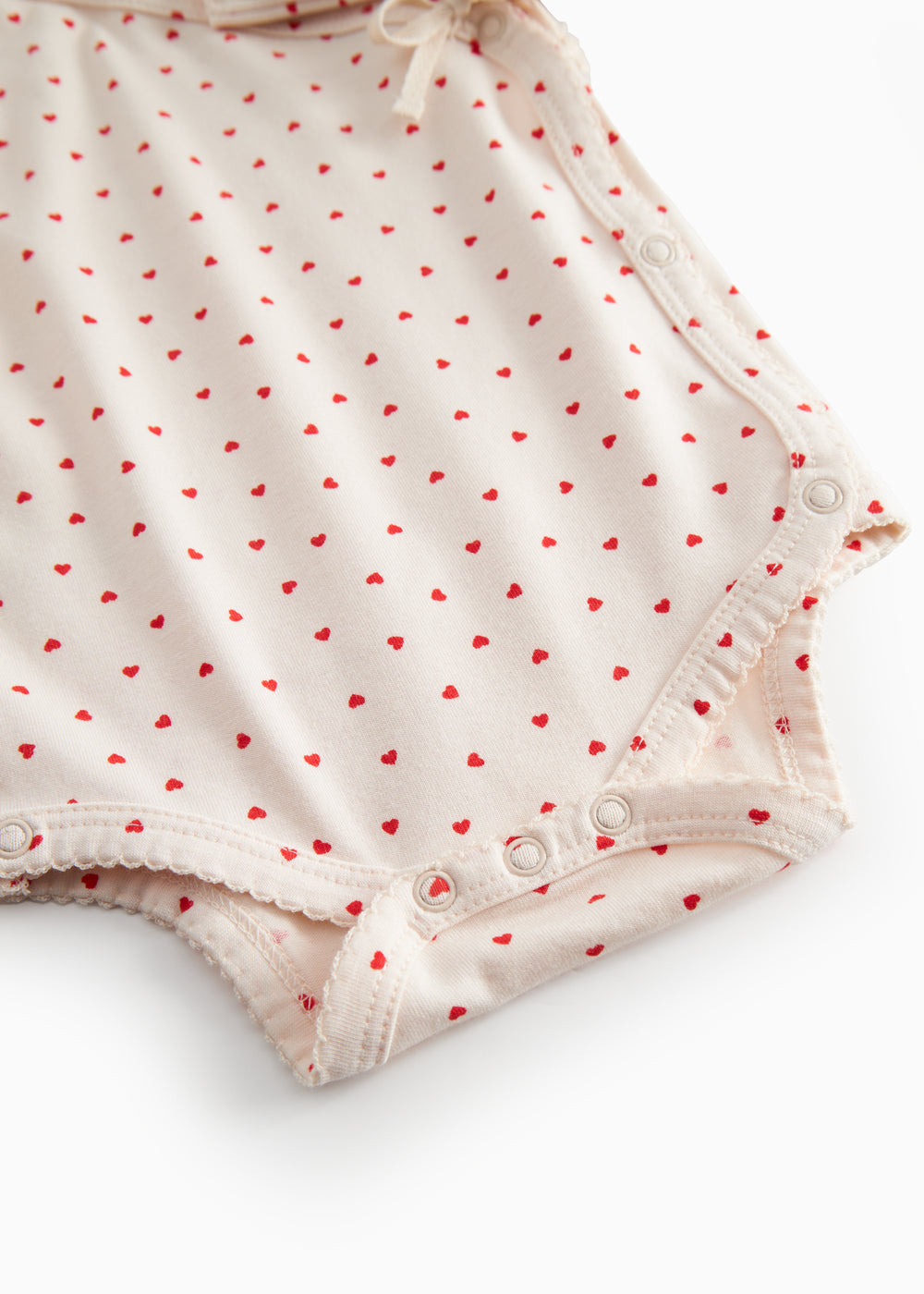 Langærmet bodystocking til nyfødte med slå-om-lukning og hjerte print