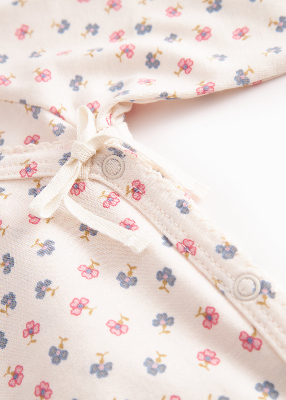 Langærmet heldragt med slå-om-lukning og blomstermønster til nyfødte