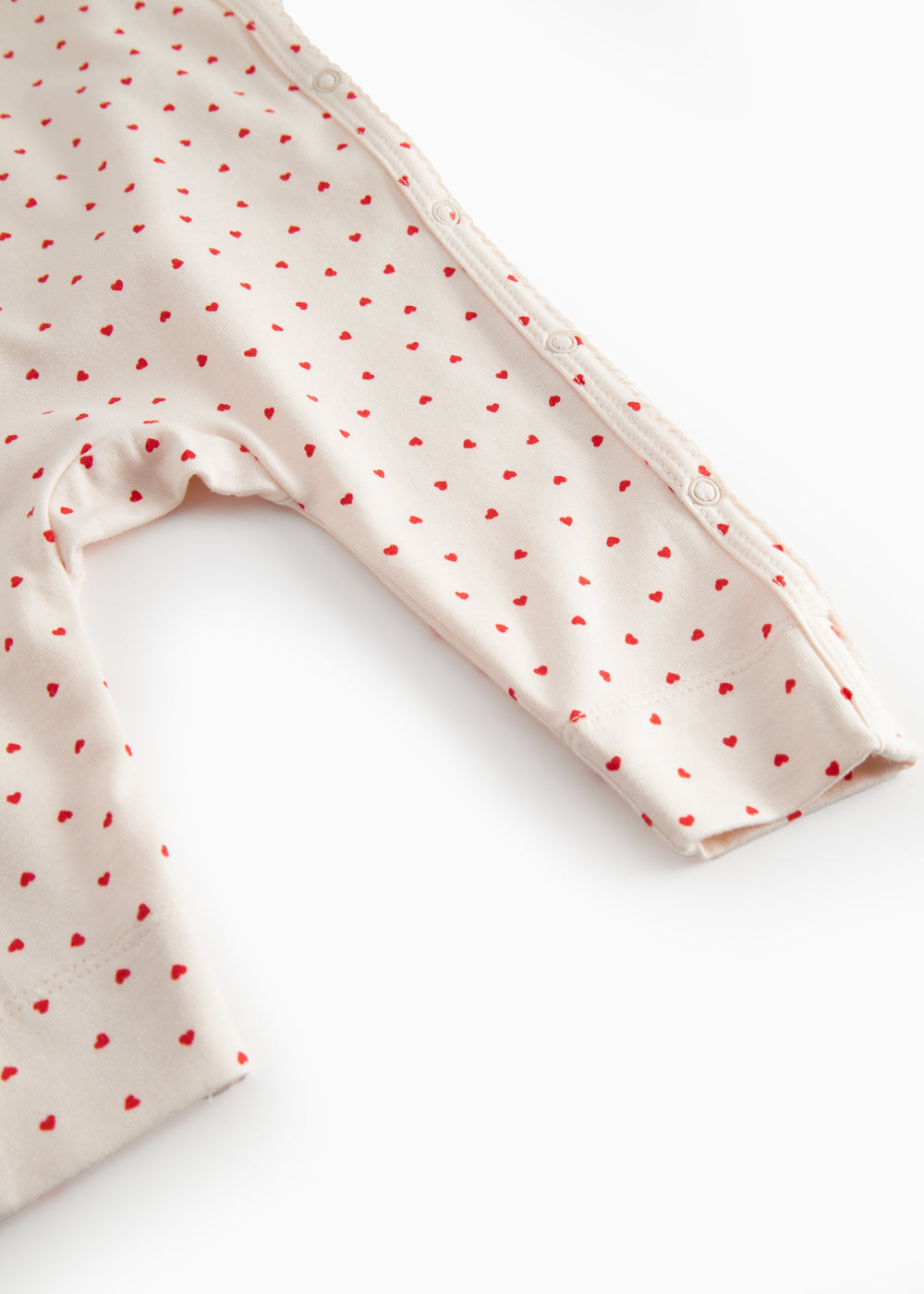 Langærmet baby heldragt med slå-om-lukning til nyfødte og fint hjerte print
