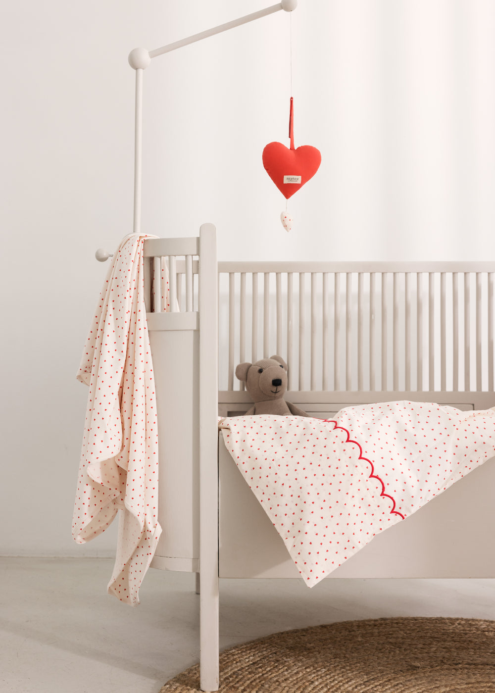 Tremmeseng med babysengetøj og rød musikuro