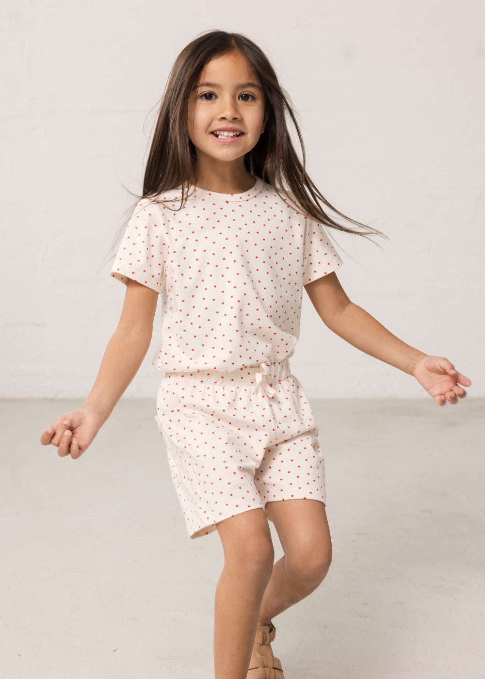 Pige iført kortærmet t-shirt og shorts med et fint hjerte print