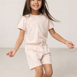 Pige iført kortærmet t-shirt og shorts med et fint hjerte print