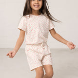 Pige iført kortærmet t-shirt og shorts med et fint hjerte print