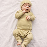 Baby iført Langærmet heldragt med grønne striber og slå-om-lukning og matchende hue