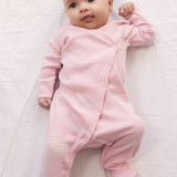 Baby iført langærmet heldragt med fødder og lyserøde striber
