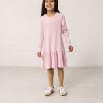 Barn iført lyserødstribet kjole med lange ærmer