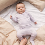 Baby iført Lys lilla bukser med fødder og matchende body