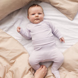 Baby iført Lys lilla bukser med fødder og matchende body