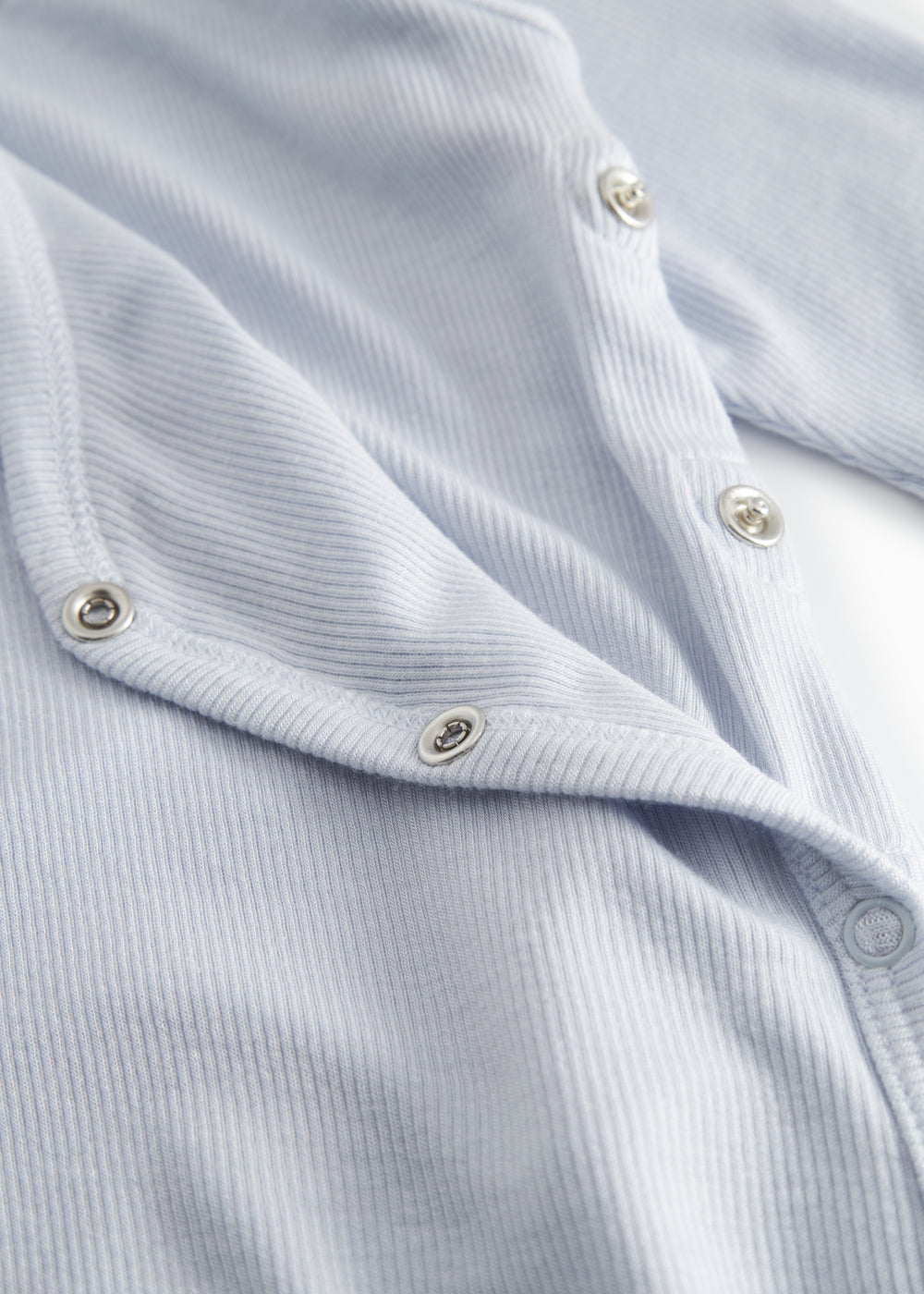 Lyseblå langærmet heldragt med slå-om-lukning til nyfødte