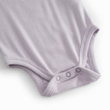 Lys lilla baby bodystocking med stropper og picotkanter.