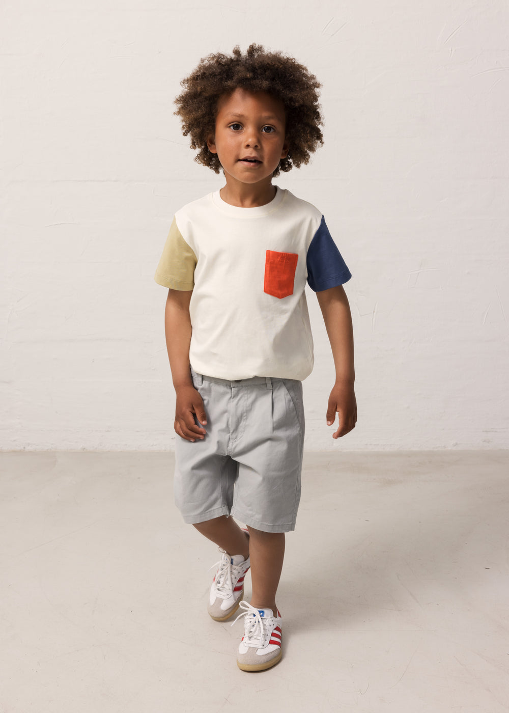 Dreng iført blå chino shorts og t-shirt