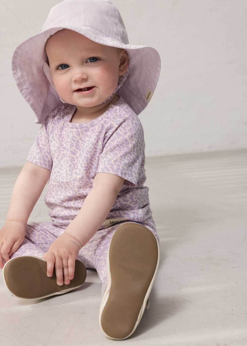 Baby iført lys lilla sommerhat og lilla leopard mønstret outfit