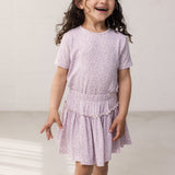 Pige iført lyserød nederdel i leopard og matchende t-shirt