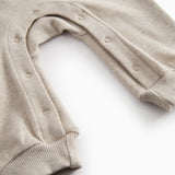 langærmet beige baby heldragt med rib i hals, ærmer og ben.