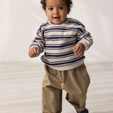 Baby iført grønne chino bukser og stribet sweatshirt