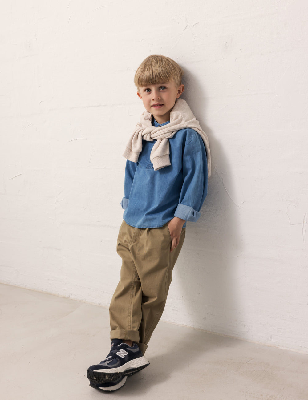 Barn iført blå denimskjorte og brune bukser