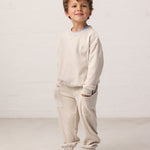 Dreng iført beige langærmet sweatshirt til børn med rib og matchende sweatbukser