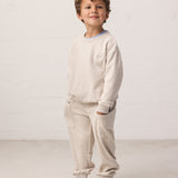 Dreng iført beige langærmet sweatshirt til børn med rib og matchende sweatbukser