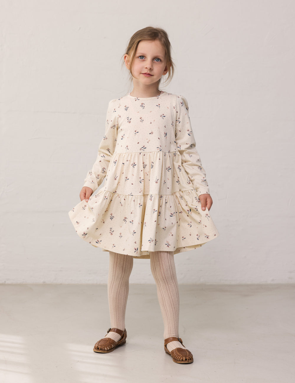Pige iført langærmet lagdelt kjole med blomster print