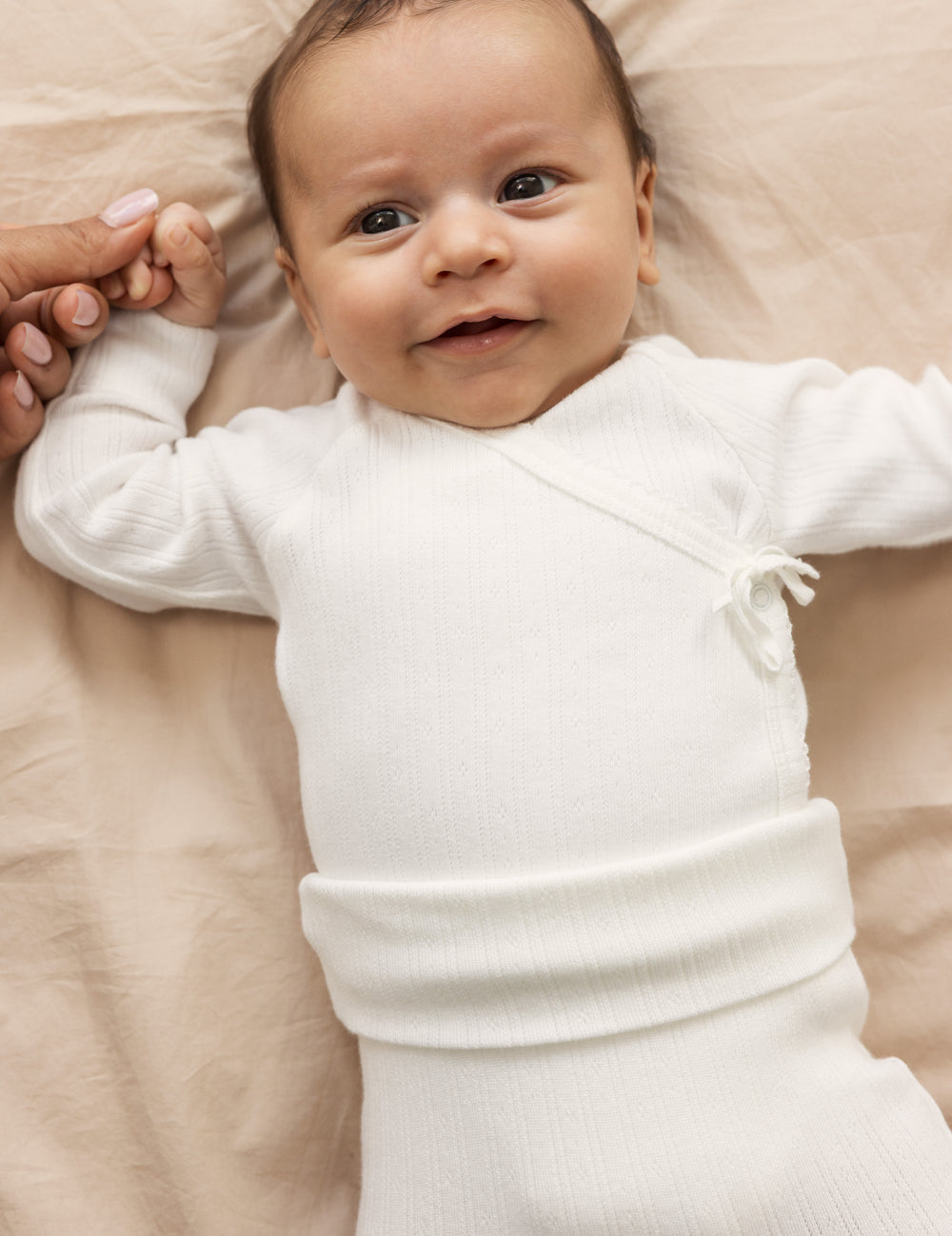 Baby iført Hvide pointelle bukser med fødder og body