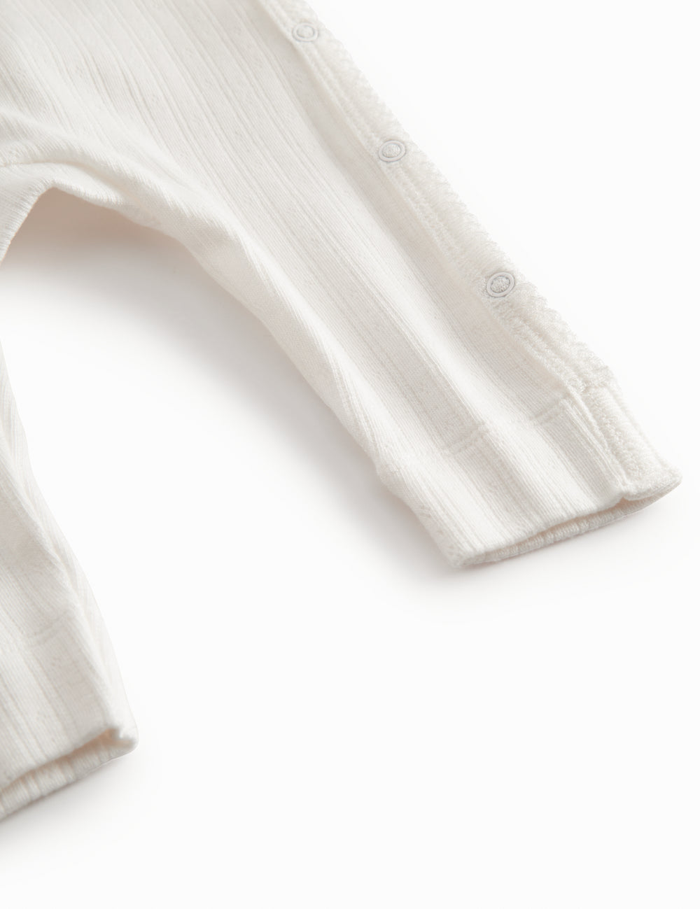 Hvid langærmet pointelle heldragt med slå-om-lukning til nyfødte