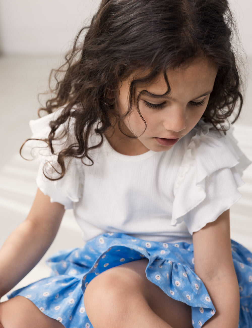 Barn iført blå nederdel med blomsterprint