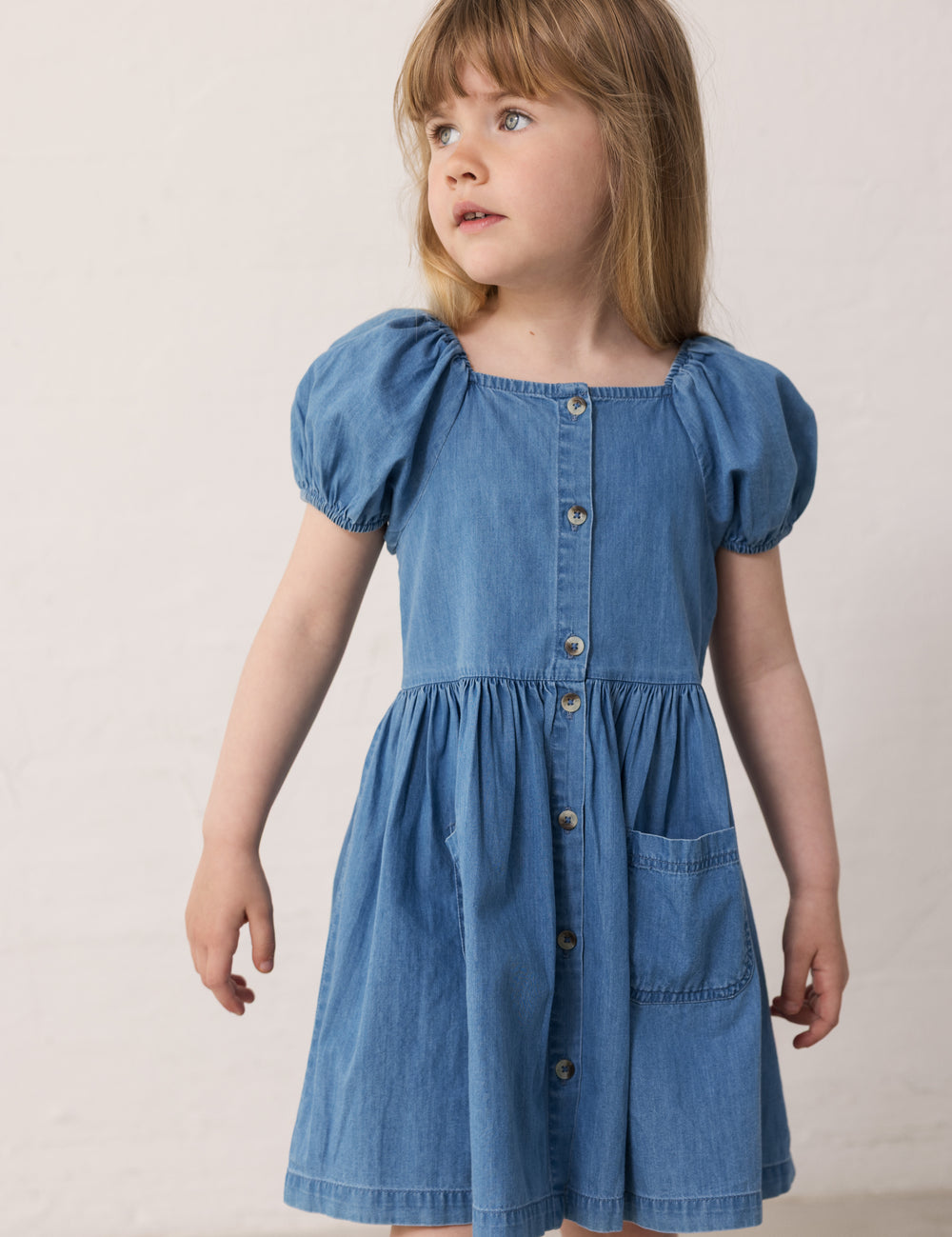 Barn iført blå kjole med korte pufærmer