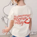 Barn iført råhvid T-shirt med Mumin-print og denimshorts