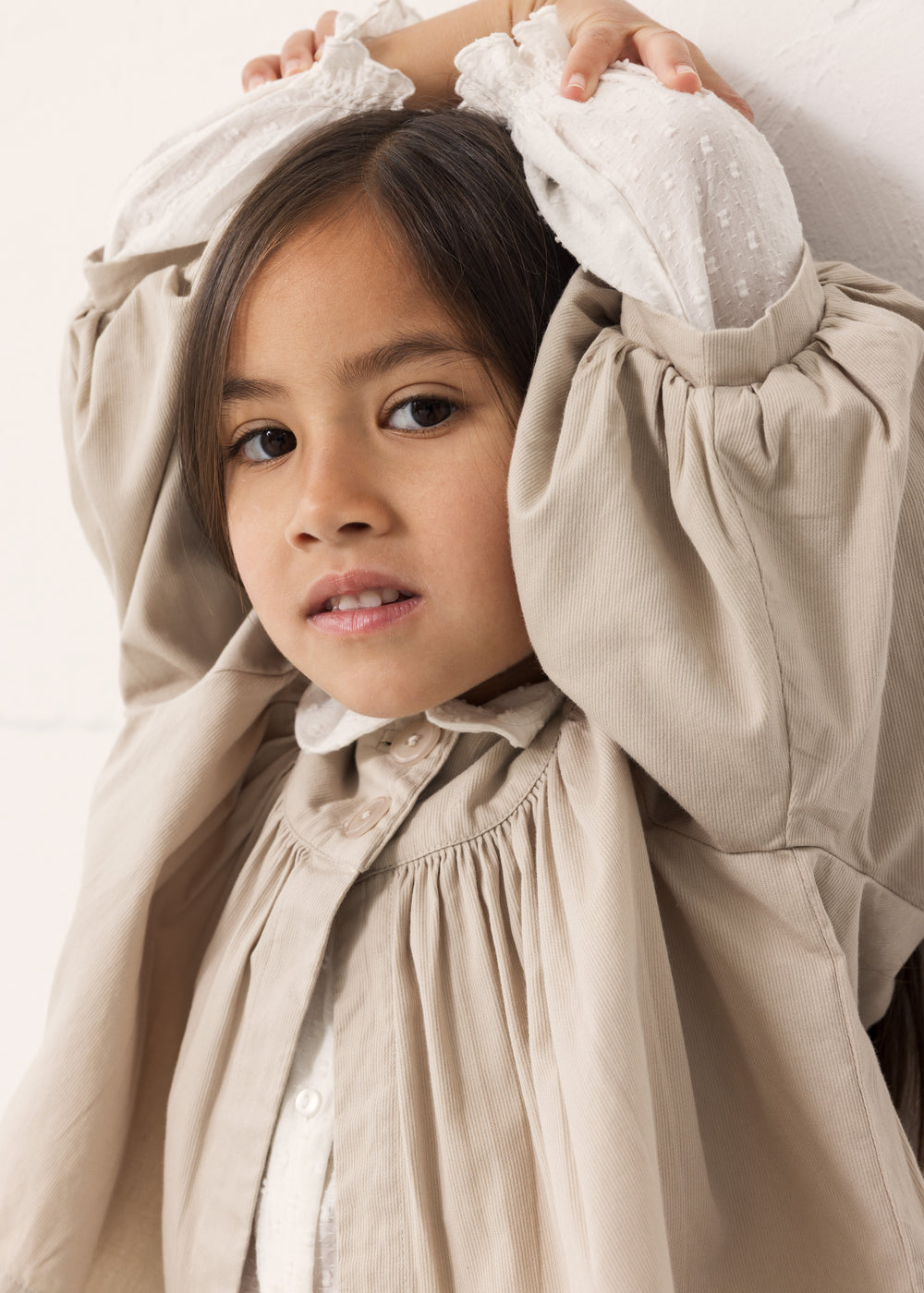 Barn iført lys bluse med flæsedetaljer