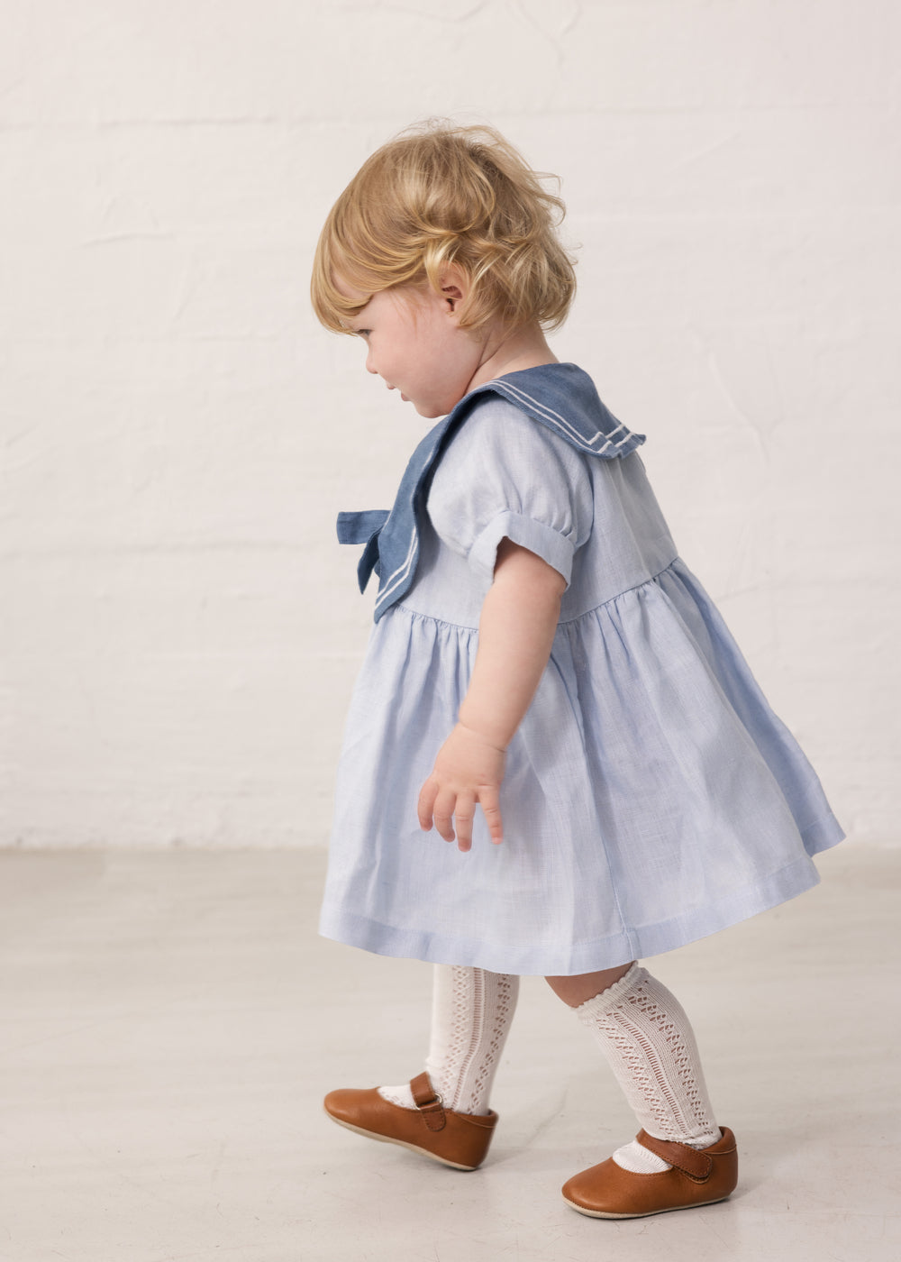 Baby iført Kortærmet kjole med fin matroskrave og sløjfe foran