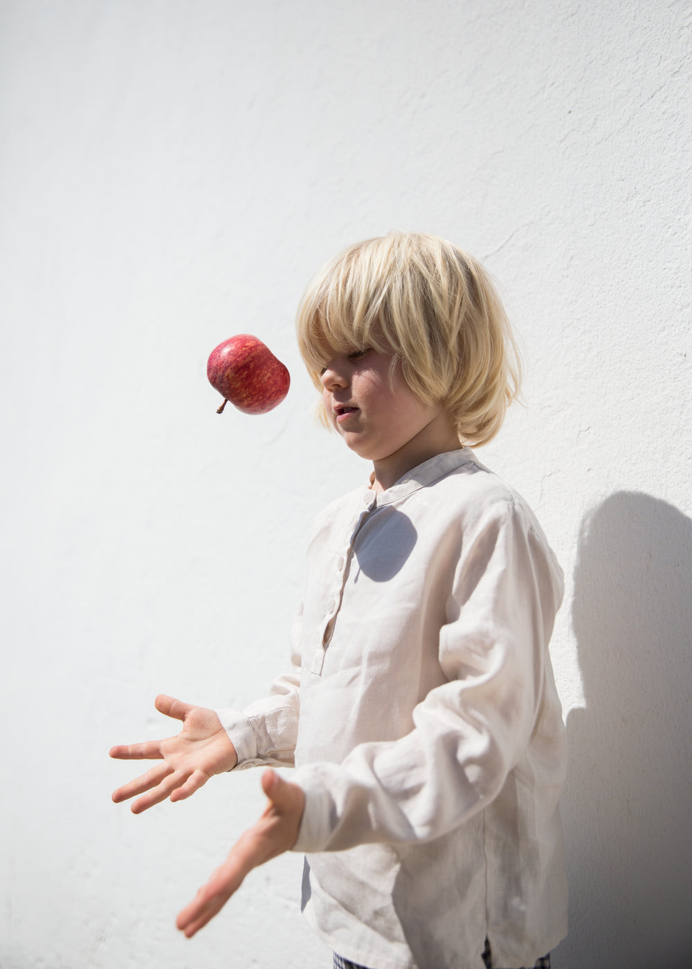 Barn iført beige skjorte med knapper