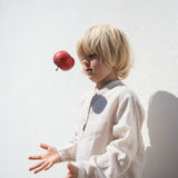 Barn iført beige skjorte med knapper