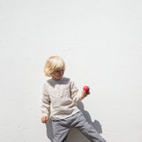 Barn iført beige skjorte og ternet bukser 