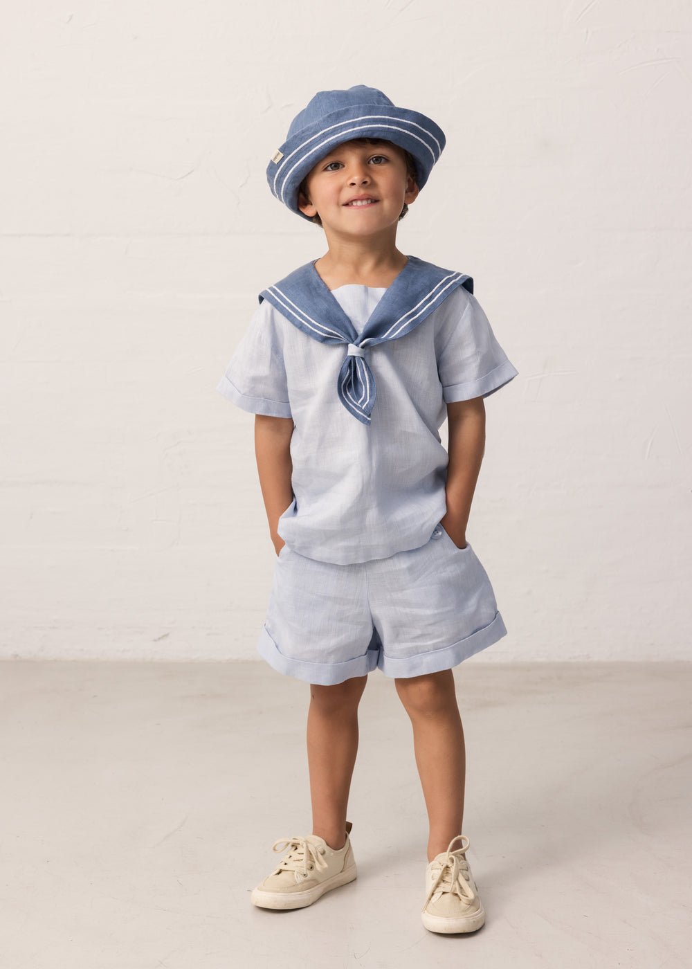 Barn iført matroshat og sjømandsinspireret sæt