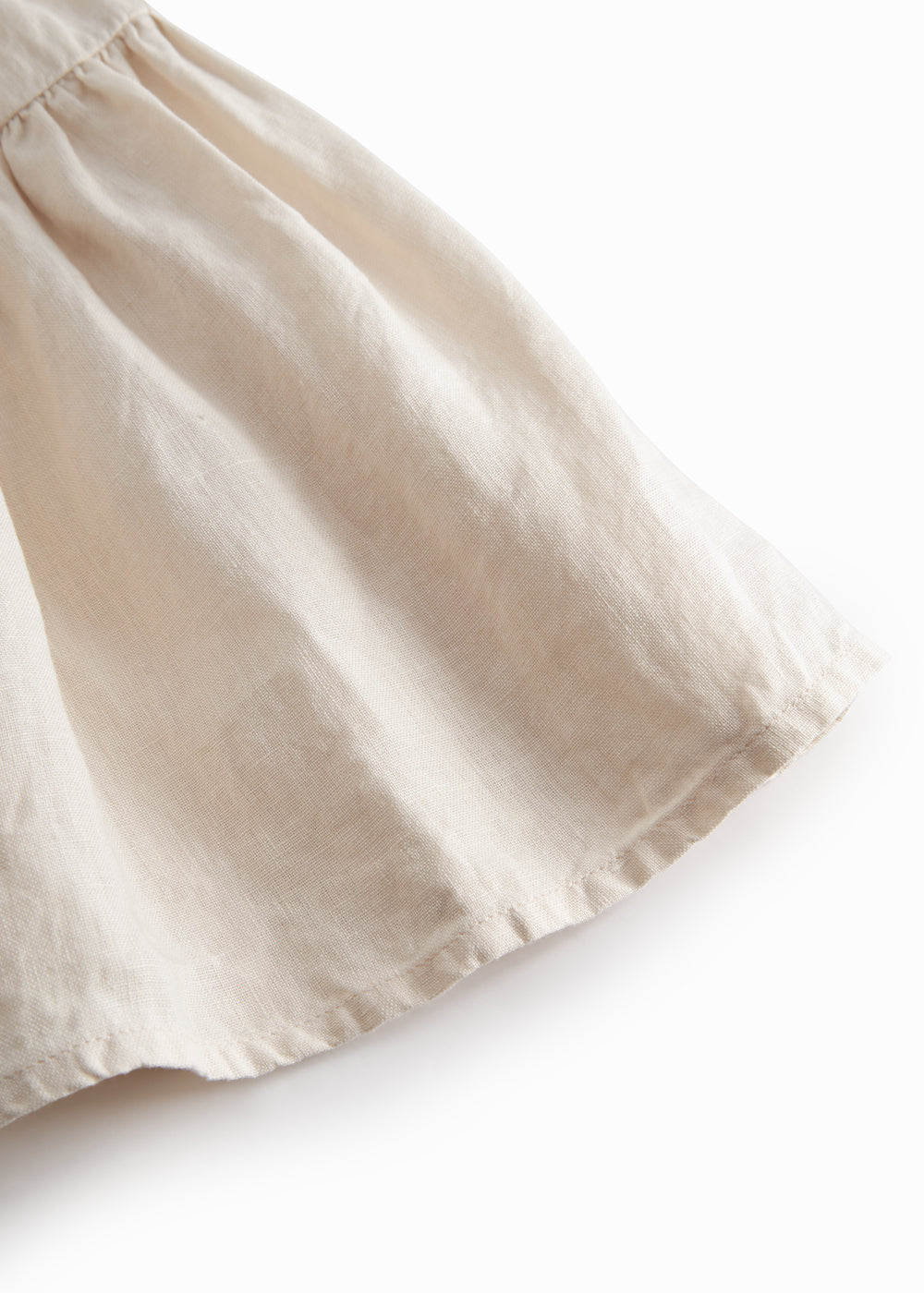 Ærmeløs beige kjole til børn med brede stropper og flæser på skulderen og smock bagpå