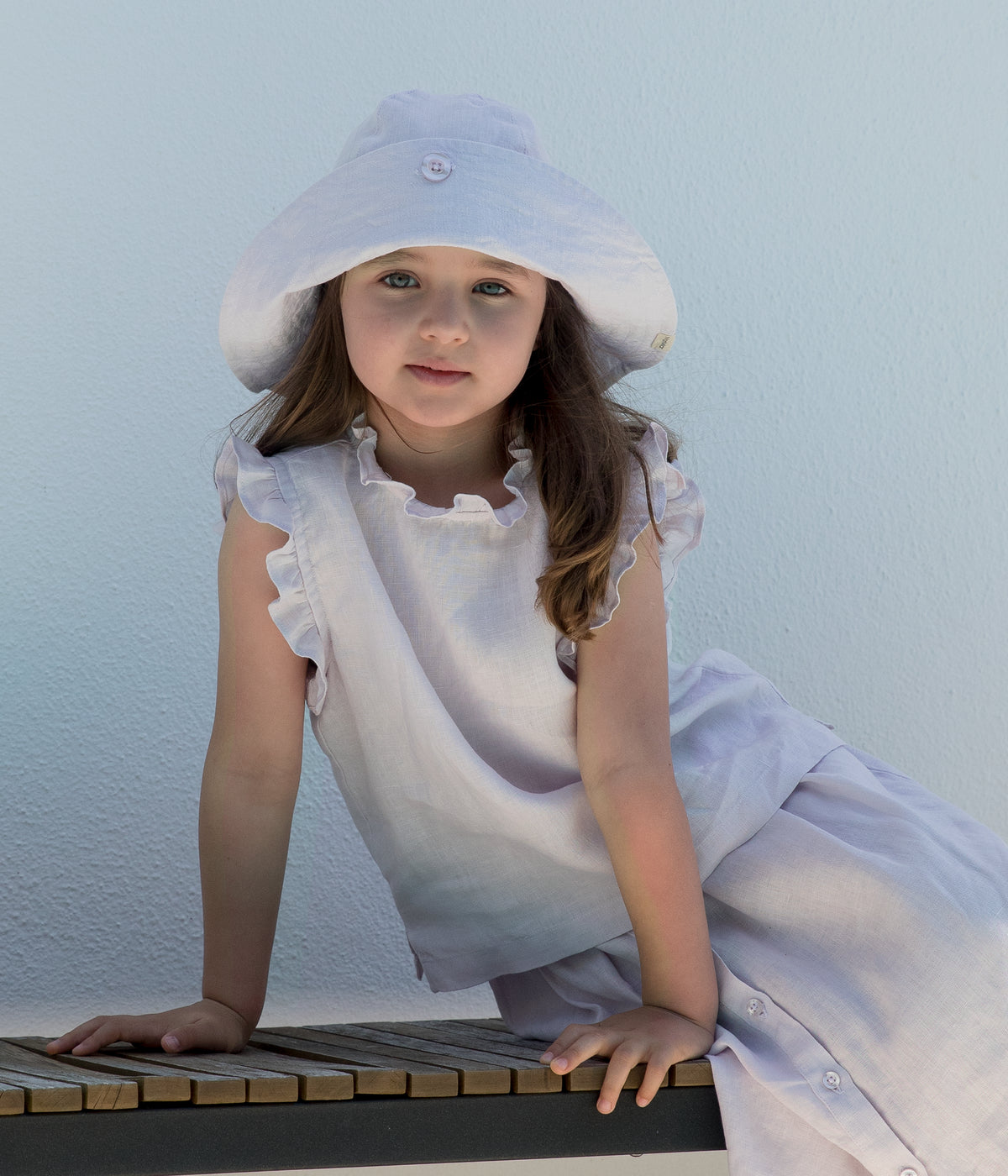 Pige med solhat og bluse med flæser