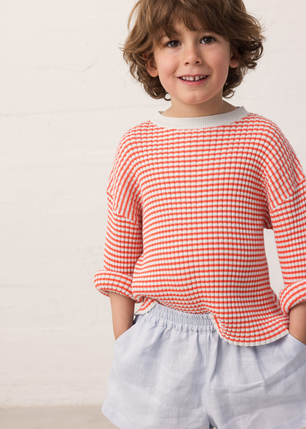 Barn iført stribet bluse og lyse shorts