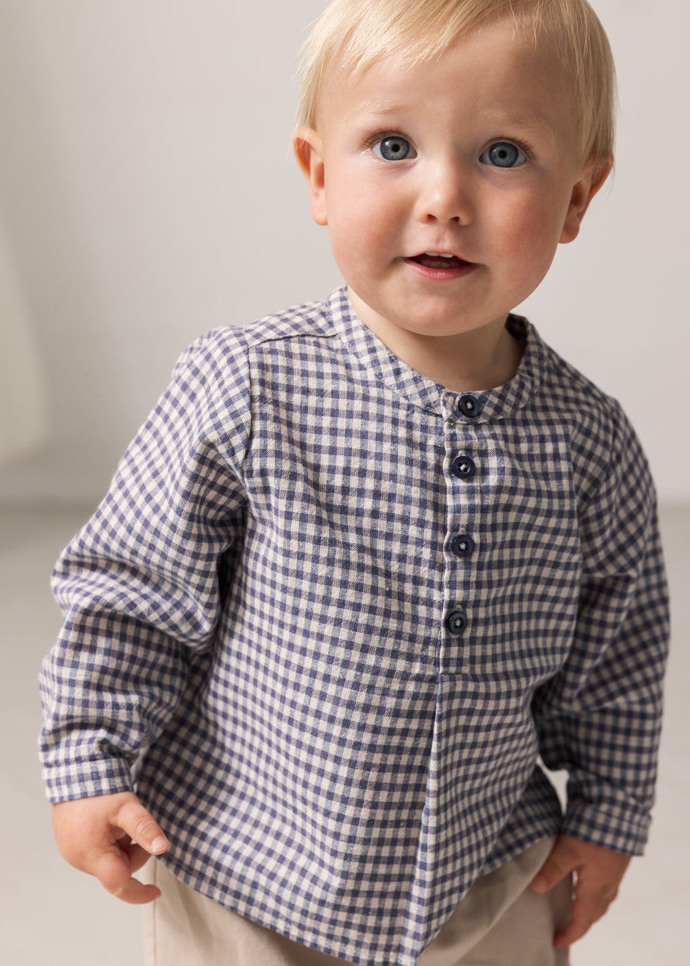 Baby iført langærmet ternet skjorte med kinakrave og knaplukning foran
