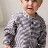 Baby iført langærmet ternet skjorte med kinakrave og knaplukning foran