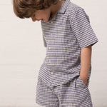 Barn iført ternet skjorte og matchende shorts