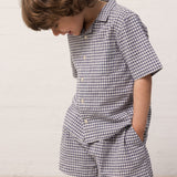 Barn iført ternet skjorte og matchende shorts